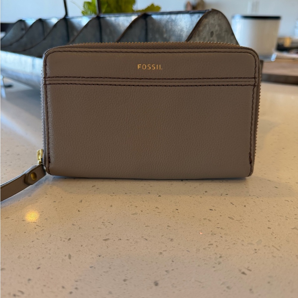 Fossil Jori Zip Clutch in a taupe or gray leather material.